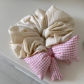 Dettaglio dell'elastico scrunchie beige con un fiocco gonfio a quadretti rosa e bianchi - Fiocco Gingham Rosa Bianco Con Scrunchie Bianco