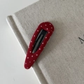 Primo piano dettagliato della clip per capelli in tessuto rosso a pois bianchi su tela - Fermaglio per capelli a goccia d'acqua scavato rosso a pois bianchi