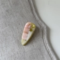 Dettaglio molletta a goccia in acetato rosa con trama marmorizzata su lino - Stile Goccia d'Acqua Rosa Bianco