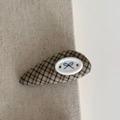Detail of blue and brown plaid hair clip with bow pattern on a beige fabric background - Coffee Trapezoid Bow