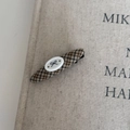 Detailed view of vintage plaid fabric hair clip on aesthetic book background - Coffee Oval Bow