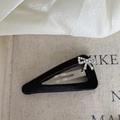 Close-up of a black satin BB hair clip with a sparkling silver rhinestone bow detail - Hollow Triangle Black Bow