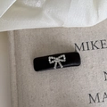Detail of a black satin rectangular hair clip featuring a delicate silver rhinestone bow - Solid Square Black Bow