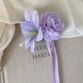 Dettaglio del fermaglio per capelli con fiori di seta viola e lunghi nastri fluidi eleganti - Fiore Viola