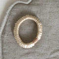 Primo piano dettagliato dell'elastico per capelli in raso oro champagne con fibbia in resina - modello base / Bianco avorio