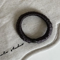 Dettaglio dell'elastico per capelli in seta marrone con decorazione a perla cilindrica nera - modello base / Marrone