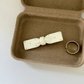 Detail of cream bow hair clip with blue dots and a silver ring in a pulp box - Single White Bow Blue Polka Dot Clip