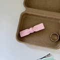Detailed view of pink polka dot bow hair clip placed inside a rustic brown cardboard box - Single Pink Bow White Polka Dot Clip
