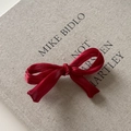Barrette à nœud en satin rouge élégante avec pois français sur un livre en lin - Style résille rouge vin / Bordeaux