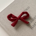 Détail de la pince à cheveux nœud en tissu rouge à pois sur un livre vintage - Style texturé rouge pur / Rouge