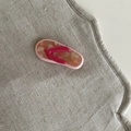 Detailaufnahme einer Haarspange in Flip-Flop-Form aus Acetat mit Schildpatt-Muster auf Leinen - Roter Riemen Flip-Flop Haarspange