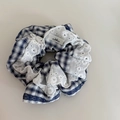 Dettaglio di elastico scacchi blu scuro con pizzo bianco e etichetta tessuta minimalista - Elastico Gingham Blu Pizzo