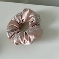 Detailansicht von rosa Satin-Haargummi mit funkelnden silbernen Strasssteinen - Rosa