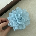Détail rapproché d'une pince à cheveux rose en gaze bleue avec des pétales en 3D - Bleu