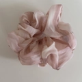 Dettaglio di un grande elastico in organza con motivo tie-dye marmorizzato rosa e bianco - Scrunchie in Rete Rosa a Righe