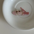 Vue macro d'une pince à cheveux pour enfant motif chien rose sur assiette blanche - Clip Rose (Pince Chien)