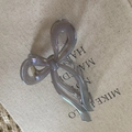 Close-up of a large ribbon bow hair claw clip in translucent smoke gray resin finish - Transparent Gray
