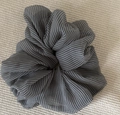 Detailed close-up of a black and white checkered scrunchie on a beige texture - Black Plaid Scrunchie