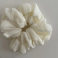 Close-up of white ruffled scrunchie with soft textured fabric and small red label - 1# White Scrunchie