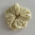 Detail of cream scrunchie fabric with a white label reading HAND MADE and a pink heart - Yellow