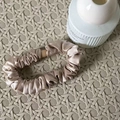 Elegante elastico per capelli in seta champagne con texture a pieghe su sfondo - Increspato / colore tè al latte