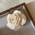 Dettaglio di un fermaglio per capelli con rosa in tessuto crema su vassoio in legno - 4# Bianco