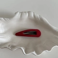 Gros plan d'une pince à cheveux goutte en tissu rouge posée sur un plat coquillage - Barrette Goutte d'Eau Ajourée Rouge (8#)