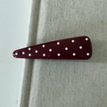 Close-up of cherry red polka dot hair clip on a natural beige linen texture background - Triangle Hair Clip