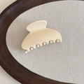 Detailed close-up of a cream jelly hair claw clip on a minimalist wooden display tray - Milky White