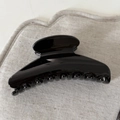Detailed close-up of a glossy black hair claw clip with a high-shine mirror finish - Black Arc Hair Claw