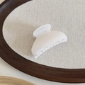 Detailed macro view of the translucent cream jelly hair claw clip on a wooden tray - Cream White