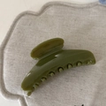 Close-up of olive green large jelly hair claw clip with glossy resin finish on linen - Green Arc Claw Clip