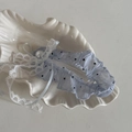 Dettaglio di giarrettiera in pizzo blu a pois con fiocco e perla su vassoio a conchiglia - Pinza per Capelli Lunga Blu a Pois Neri