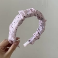 Dettaglio del cerchietto rosa a pois con trama in tessuto plissettato e morbida imbottitura - Rosa Plissettato Pois Neri
