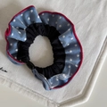 Franse vintage lichtblauwe scrunchie met stippen en rode bies op witte stoffen achtergrond - Blauw met witte stippen