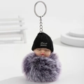 Süßer schlafender Baby-Puppen-Schlüsselanhänger mit lila Pelzball und Mütze - Lila