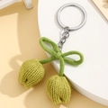 Nahaufnahme von grünem gestricktem Tulpen-Schlüsselanhänger mit Schleife auf Weiß - Grün