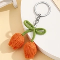 Detailansicht der handgestrickten orangefarbenen Tulpen-Schlüsselanhänger mit Bogen - Orange