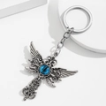 Portachiavi a croce gotica d'argento con ali d'angelo e occhio blu su sfondo bianco - Stile Croce Alata - Occhio Blu
