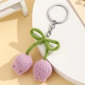 Handmade knitted lavender tulip keychain with green leaves and a bow on white stand - Purple