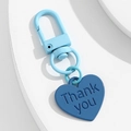 Detailansicht eines blauen Herz-Schlüsselanhängers mit Thank You Gravur im Detail - Blau