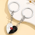 Close-up of interlocking heart keychains with minimalist stick figures in black and white - Black and White Heart