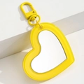 Primer plano de un llavero de espejo amarillo con forma de corazón y cierre de mosquetón - Amarillo