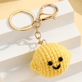 Detail eines handgefertigten Häkel-Smileys mit einem hochwertigen goldenen Metall-Schlüsselring - Zitrone