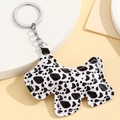 Close-up of Scottish Terrier dog keychain featuring black and white cow print leather detail - Black White Cow Print