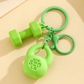 Detail shot of green fitness keychain featuring a mini dumbbell and kettlebell charm - Green