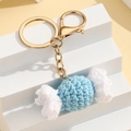 Macro-opname van handgemaakte gehaakte snoepsleutelhanger in blauw met gouden clip - Blauw Wit Snoepje