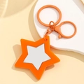 Dettaglio del portachiavi a stella arancione con specchio argento e moschettone coordinato - Arancione