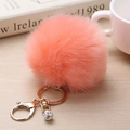 Gros plan du porte-clés pompon corail en fausse fourrure avec pendentif en strass doré - 8cm / Orange Clair