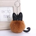 Dettaglio del portachiavi a forma di gatto in peluche marrone con orecchie in pelle nera - Pompon da 8 cm / caffè